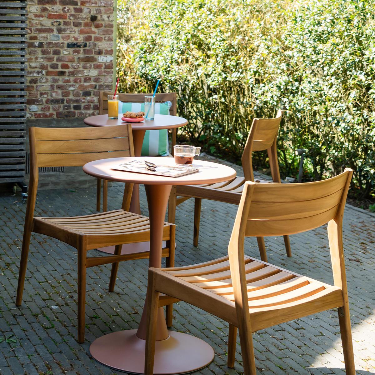 Terrasse de café aménagée avec le salon de jardin Paloma et les chaises en teck Naples mêlant bois, acier et mobilier extérieur moderne pour ambiance conviviale et haut de gamme