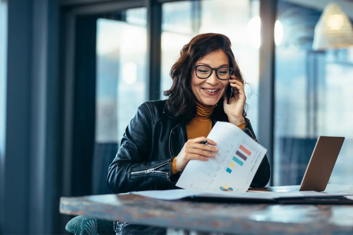 Business broker actively conducting buyer outreach with deal documents on display