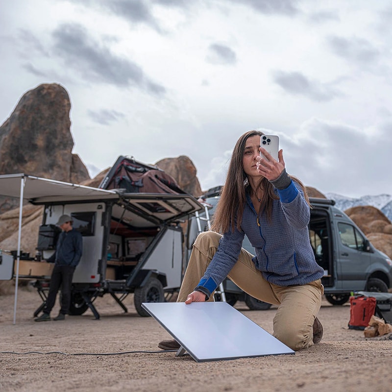 Person setting up Starlink dish near a van