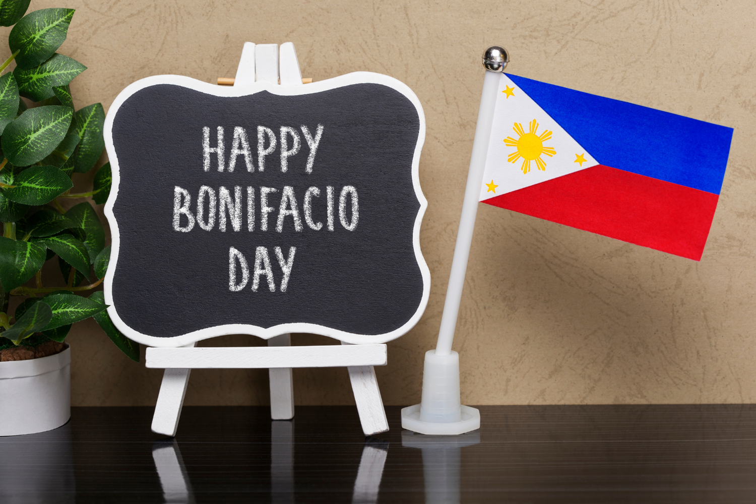 A sign saying "Happy Bonifacio Day" with a Philippine flag.