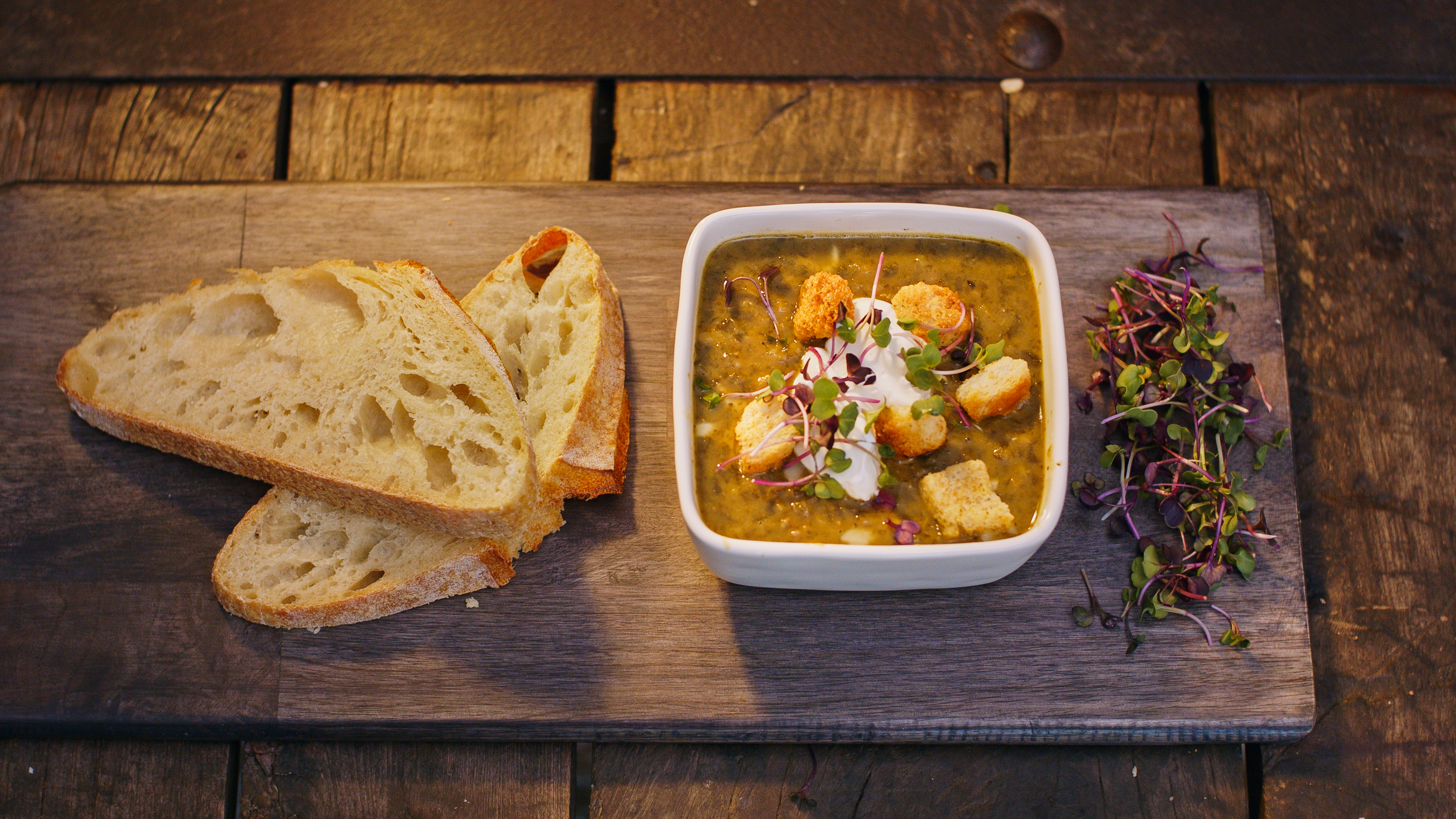 A plate with Proper Good's Split Pea & Kale Soup, whole grain bread, and fiber-rich vegetables