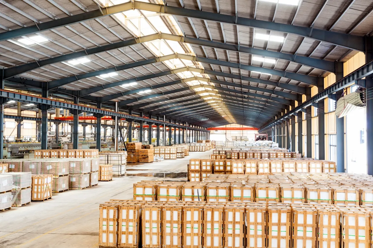Large industrial warehouse with high-volume pallet storage, featuring neatly stacked wooden crates and pallets ready for distribution or long-term storage