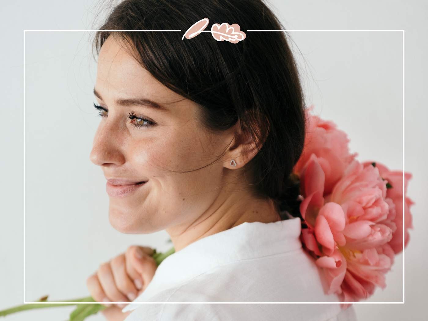 A woman smiling with a bouquet of soft pink peonies over her shoulder, from '11 Fabulous Reasons to Buy Peonies'