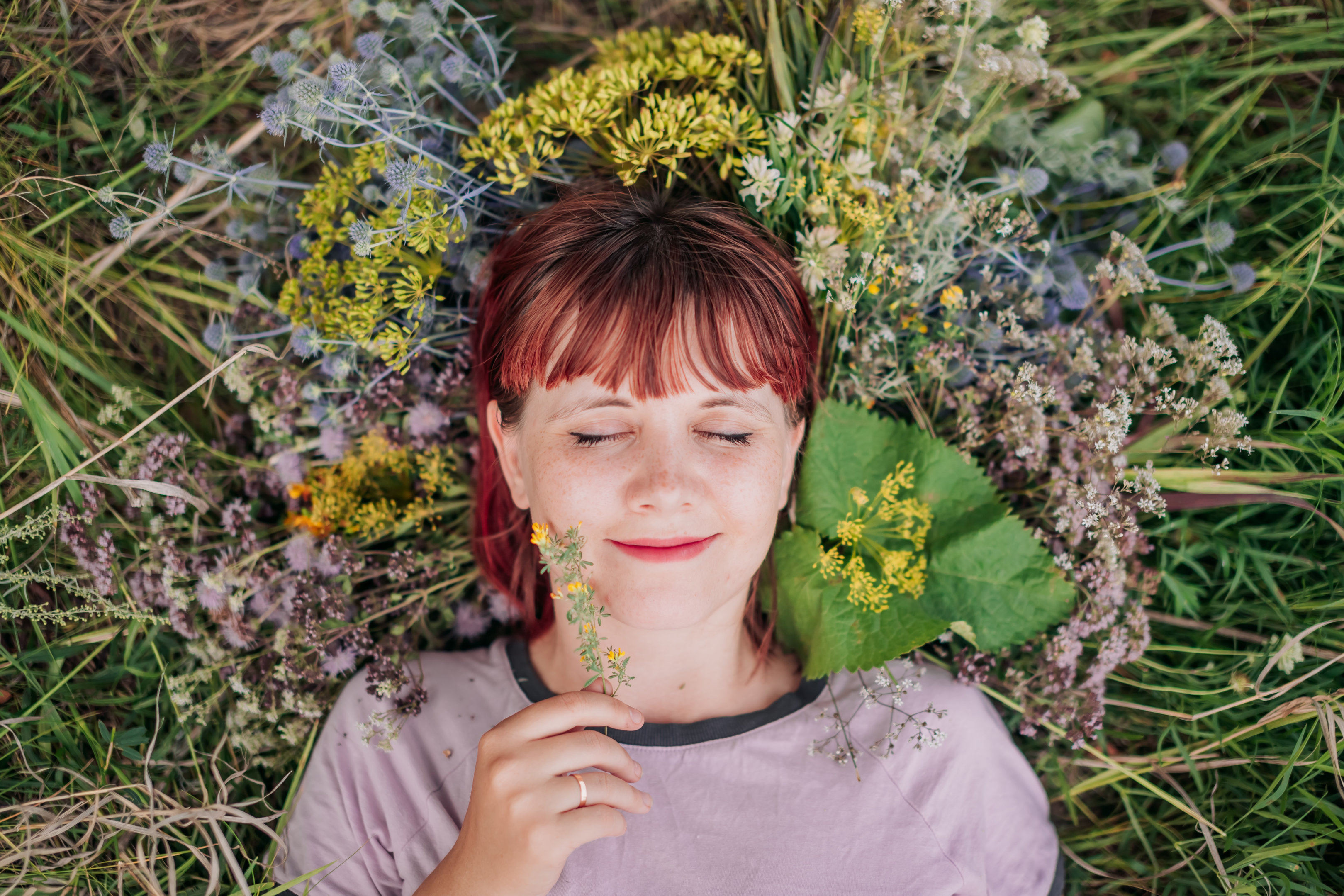 Photo of a girl lying down in the ground full of colorful flowers