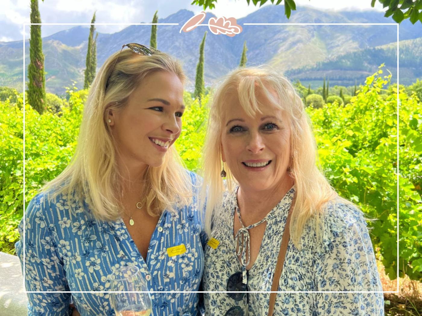 Mother and daughter standing in a vineyard, smiling at each other. A beautiful setting for celebrating special moments.