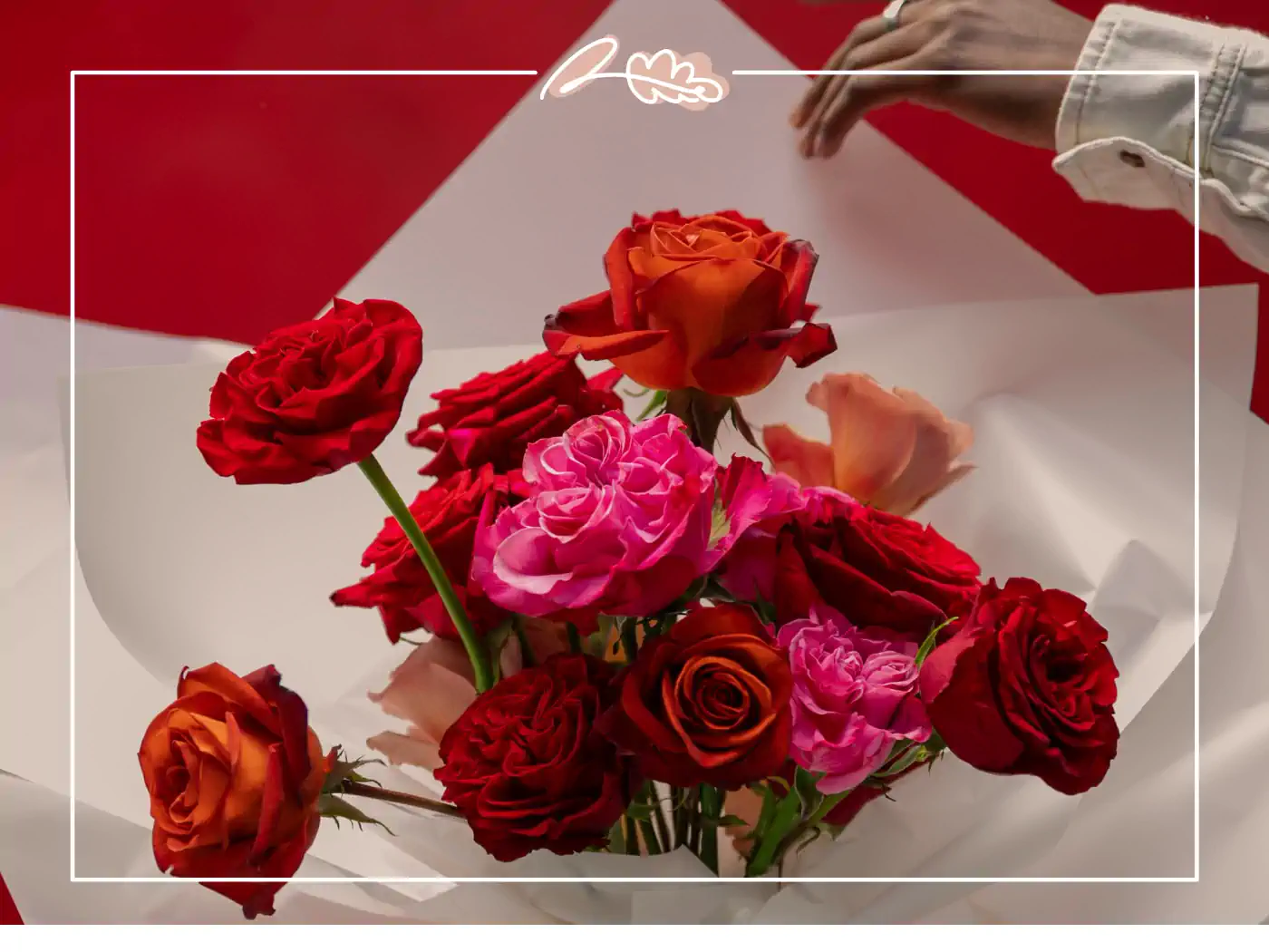 Red and pink roses being carefully arranged on a white and red background. Fabulous Flowers and Gifts