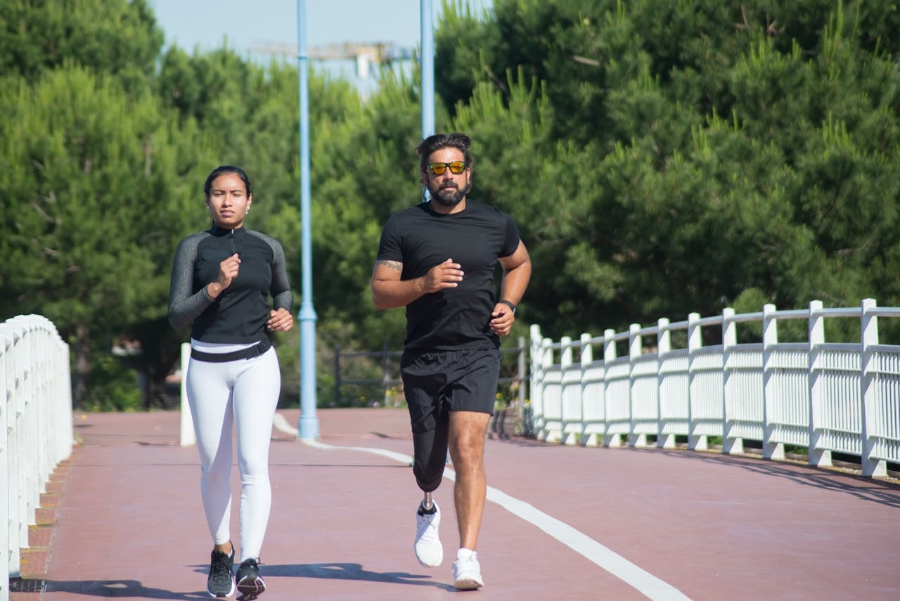 Two runners jogging on a path, illustrating low-impact cardio options often recommended after knee replacement recovery.