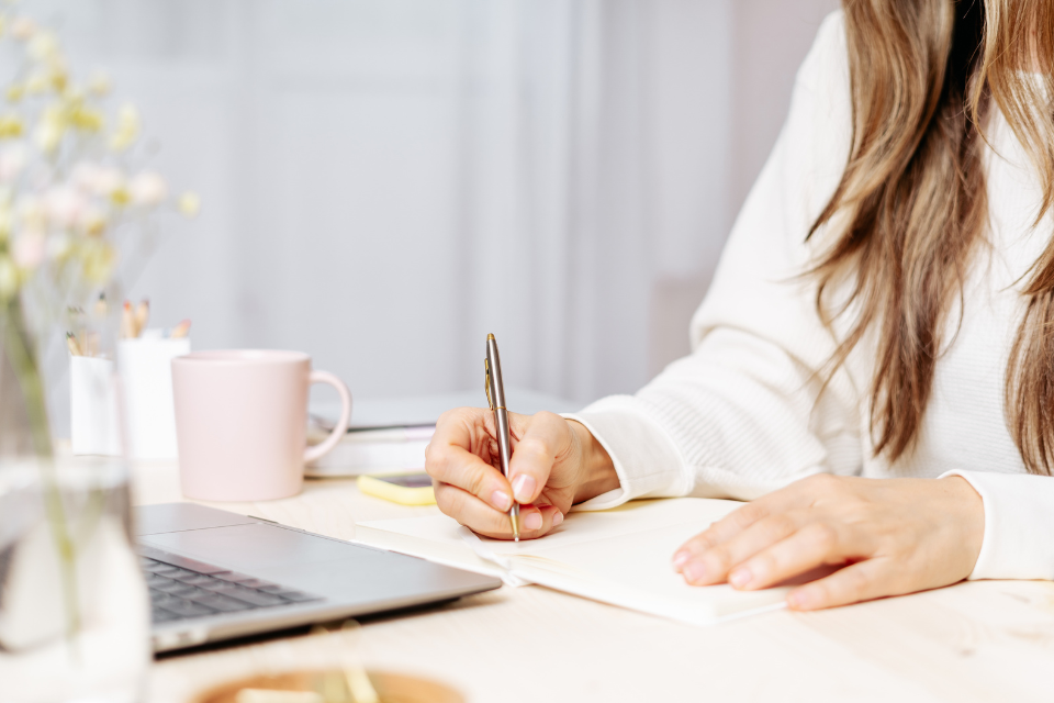 woman working at desk makes notes about an SEO content audit