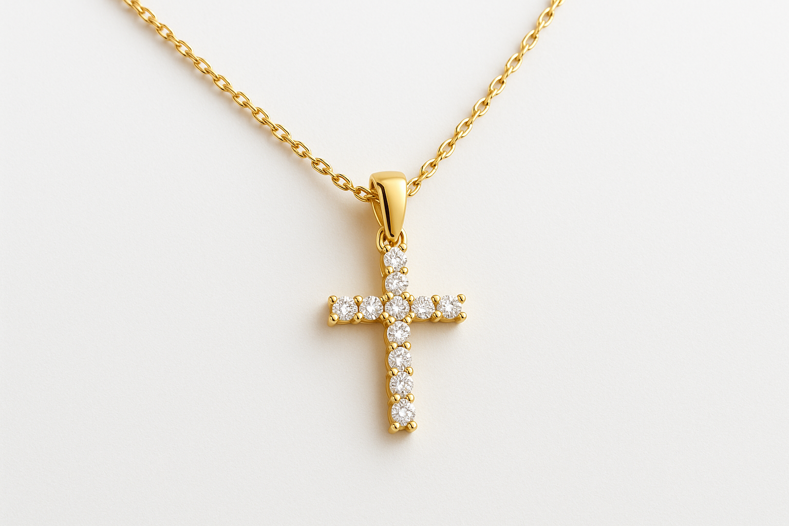 Auksinis kryželis su deimantais ant balto fono