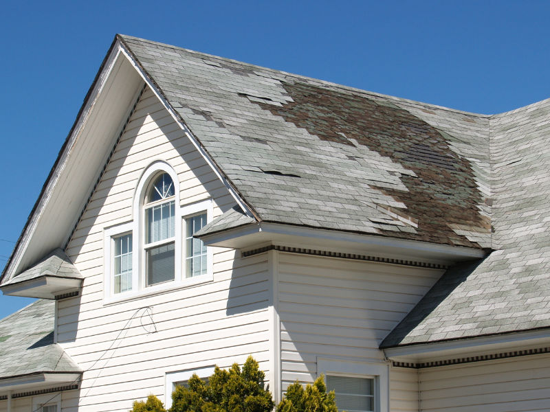 An image with roof shingles damaged in need of repairing by a roofing professional.