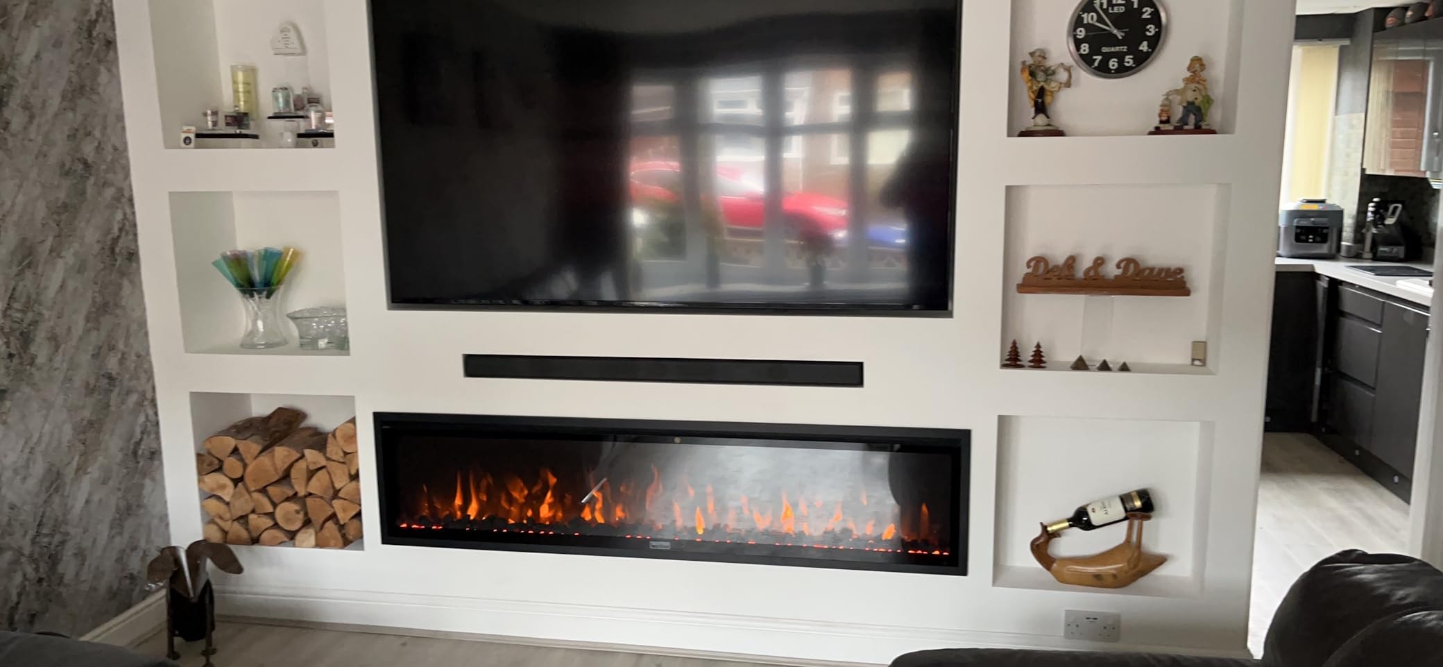 A cozy living room featuring a media wall electric fire as a focal point.