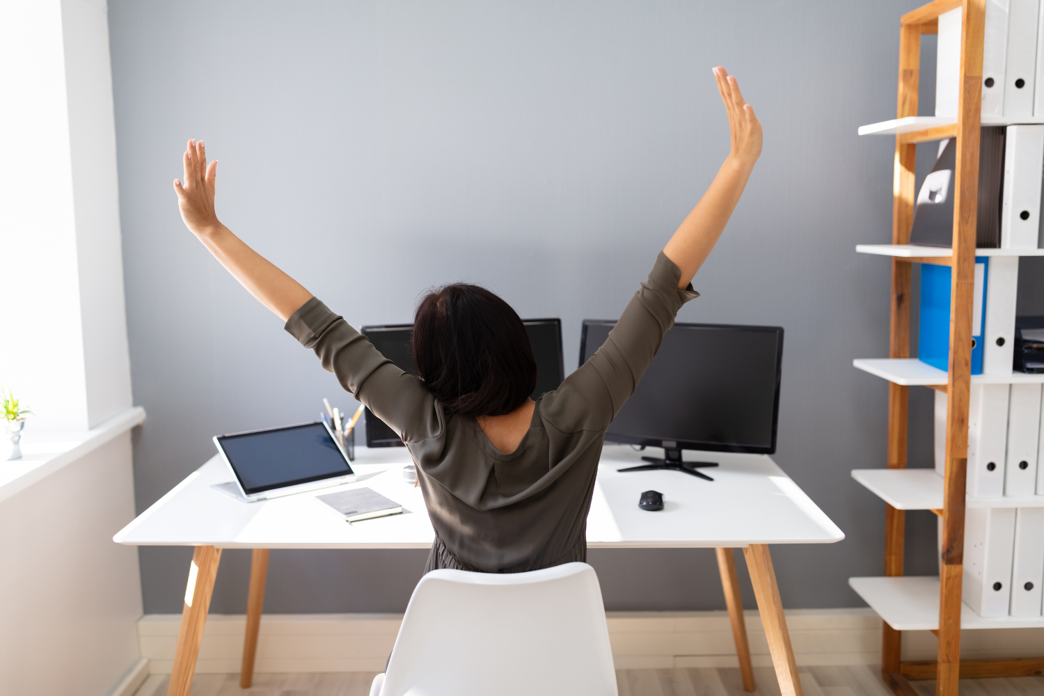 A work-from-home office setup with a remote employee stretching.