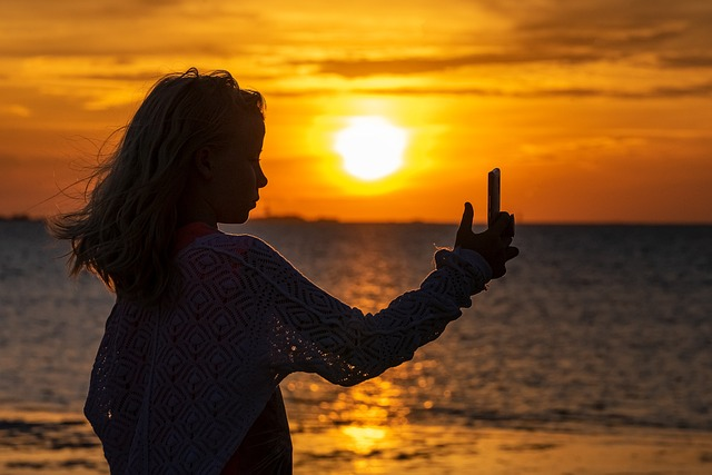 A woman's beach selfie at sunset.