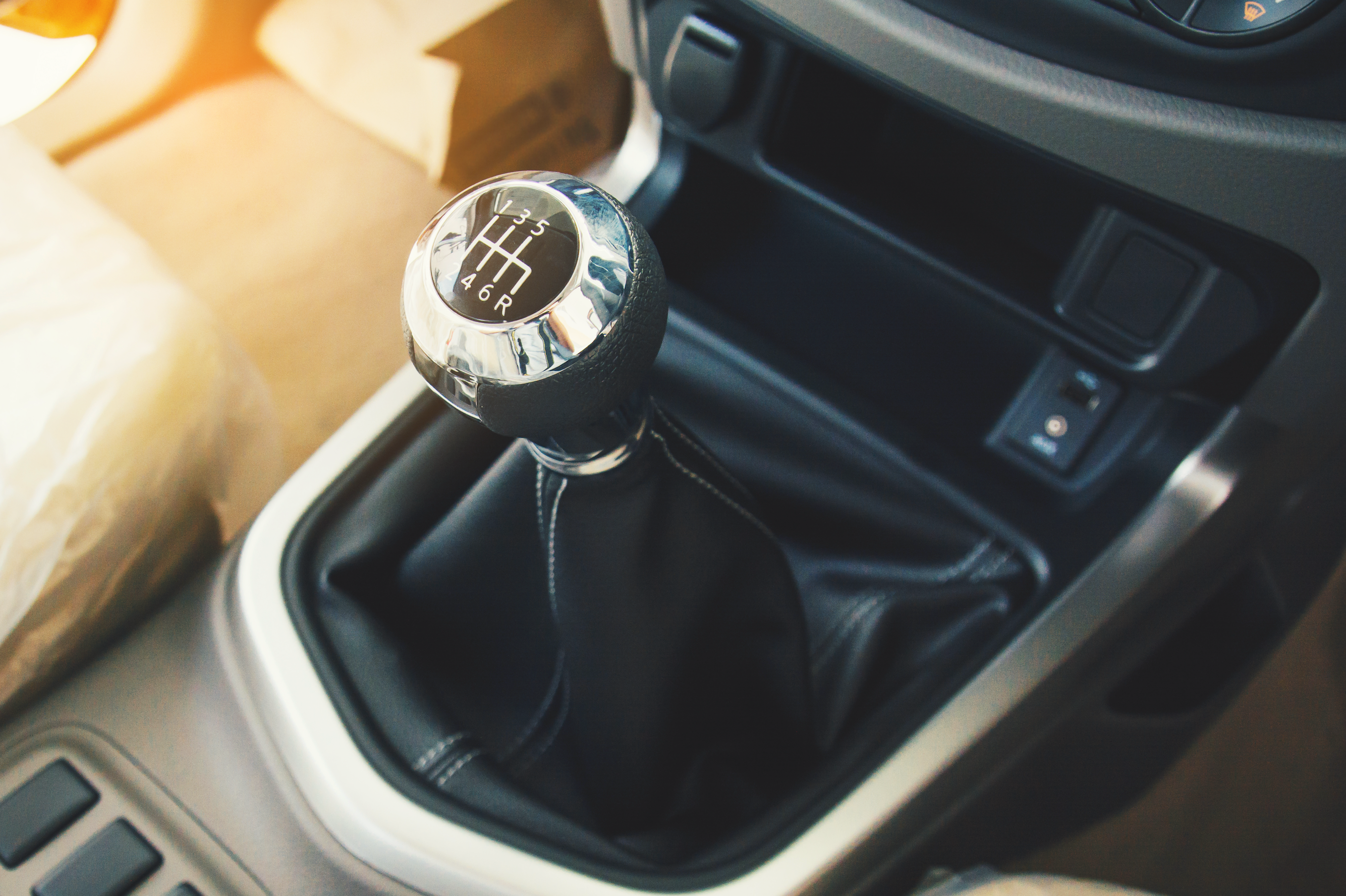 inside a vehicle a gear shift sits in the middle of the vehicle