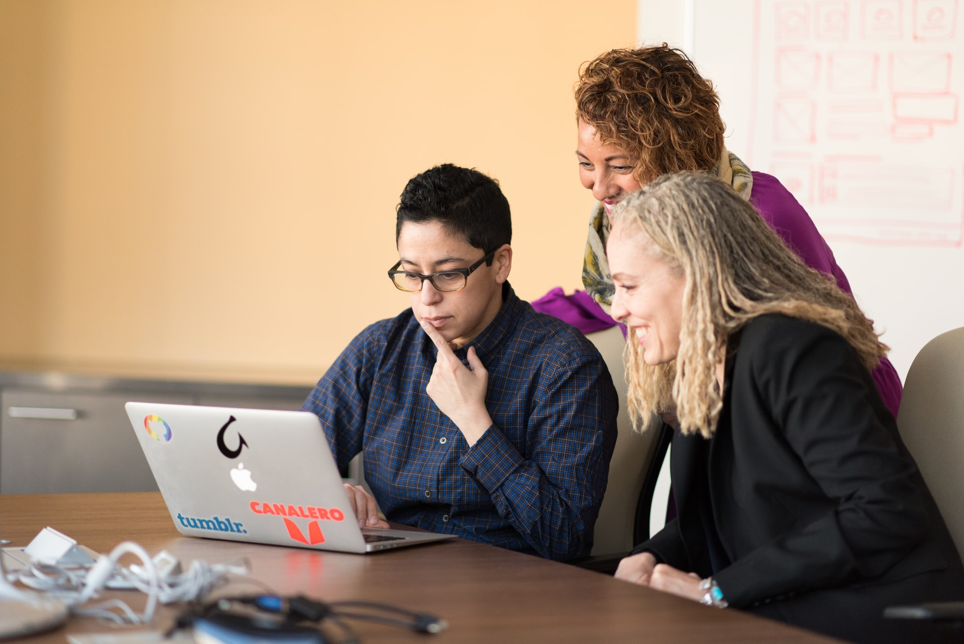 People sitting in front of a laptop looking at translation tools in a certified translation office