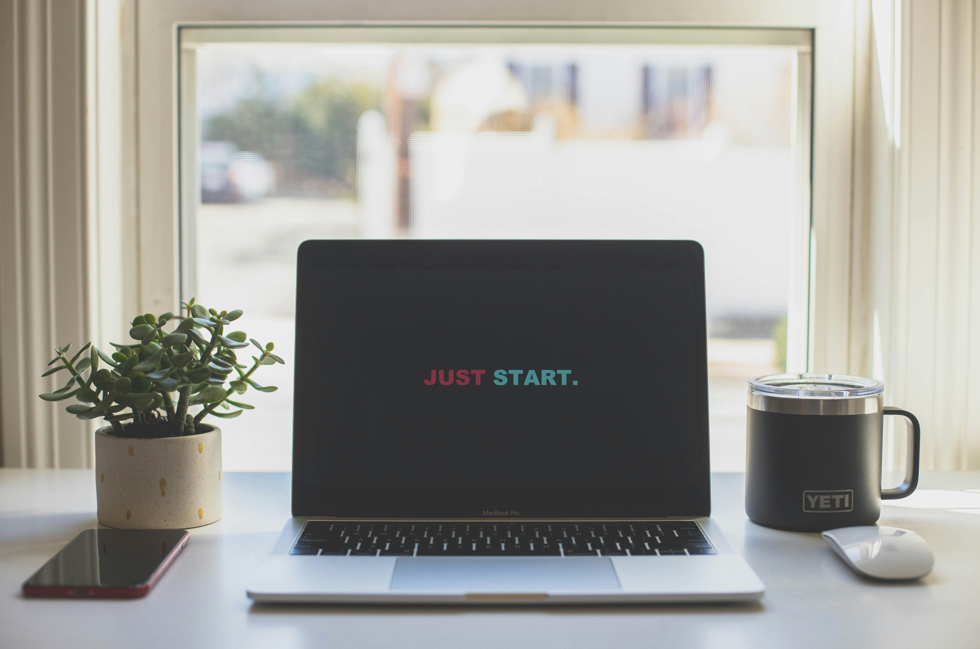 Laptop on a table that says just start