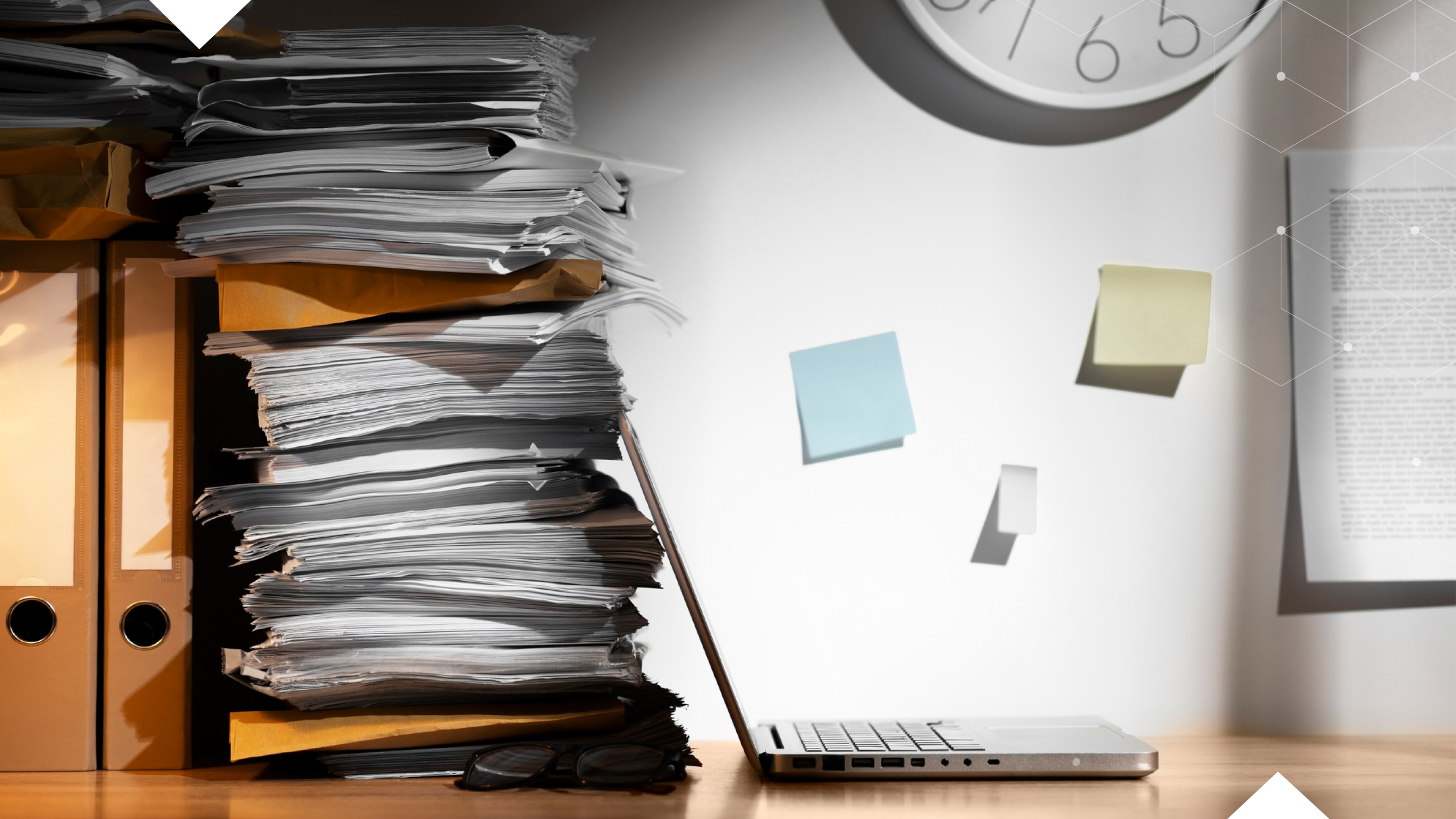 Office desk with stacked telecom invoices and contracts beside a laptop, symbolizing tracking and managing telecommunications expenses.