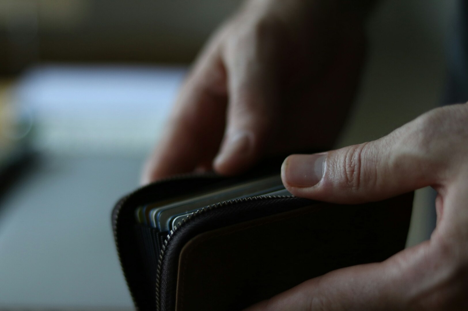 A close-up of a person’s hand holding a wallet with a visible credit card, representing salary and personal finance.