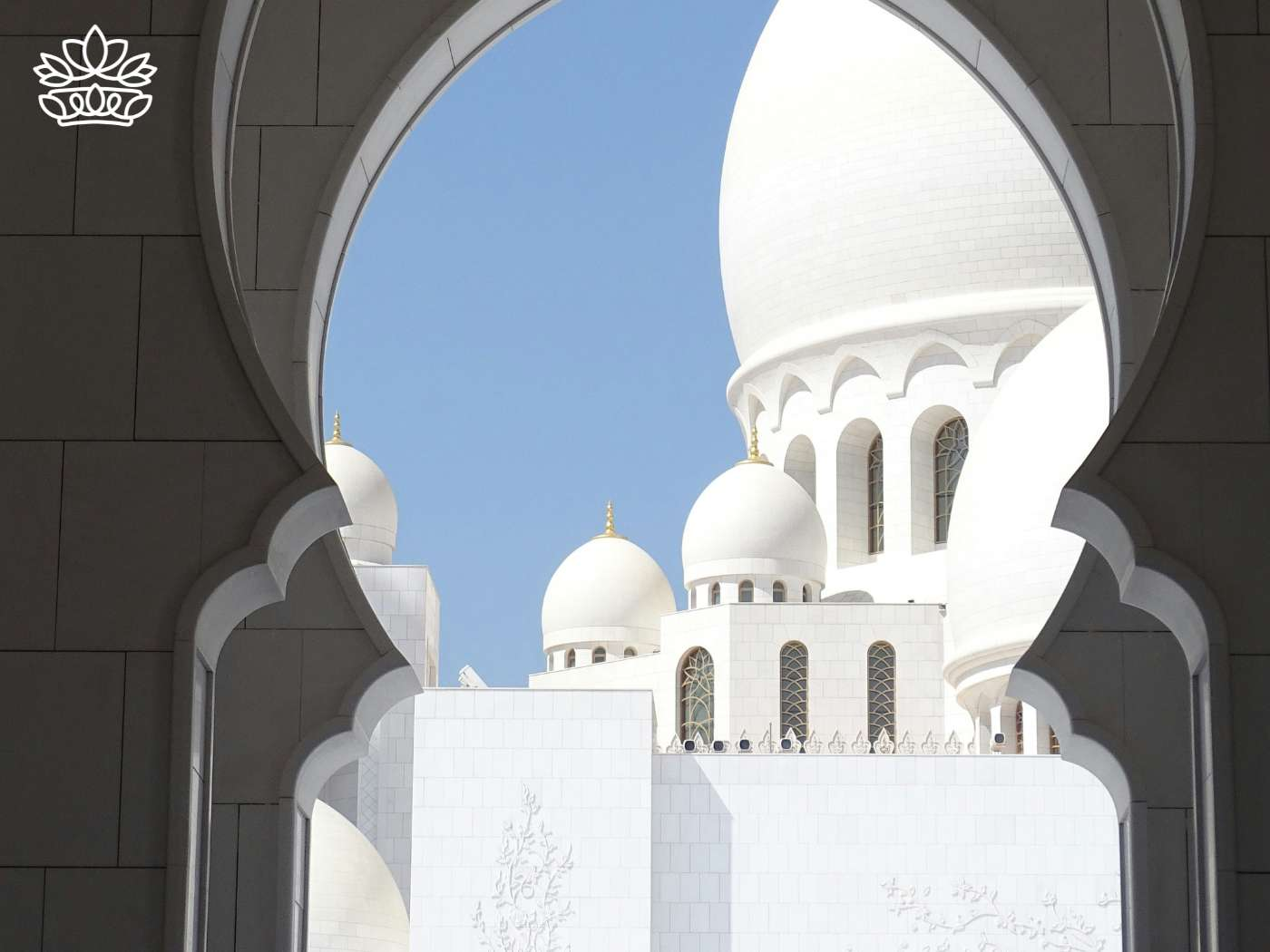 View of a majestic mosque captured through an archway, symbolizing the Islamic teachings of Muhammad, where Muslims gather in celebratory clothes among friends to honor and celebrate their faith in God, featured in the Eid Collection by Fabulous Flowers and Gifts.