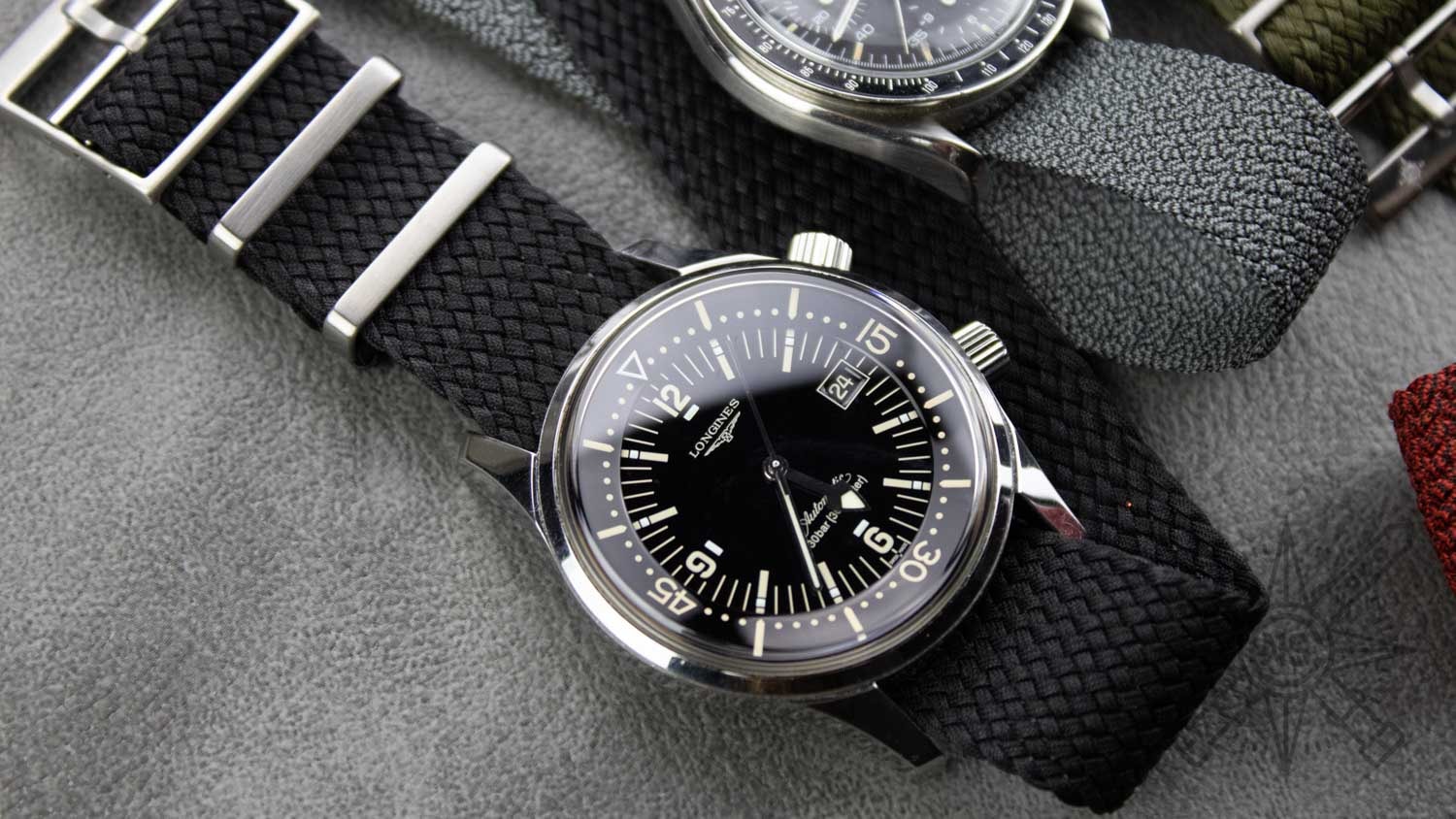 A close-up view of a black perlon strap on a watch.
