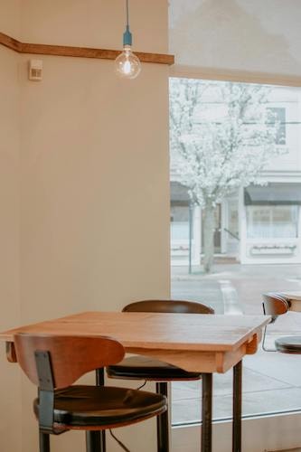 Empty seats in a New England restaurant in the early spring, blossoms on trees outside of one of the most charming towns