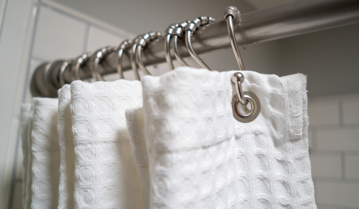 Close up of shower curtain rod - linen curtain on 'S' hooks - chrome tension rods 