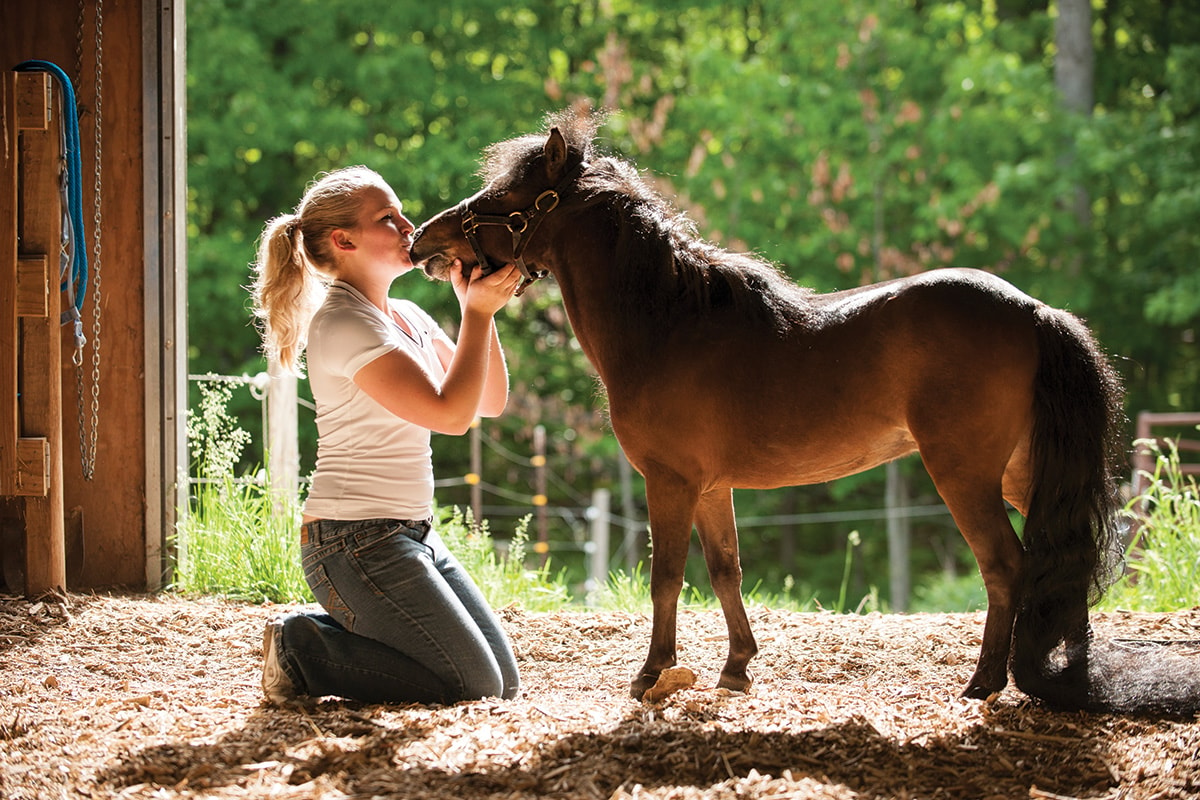 Horse owner with her brown miniature horse