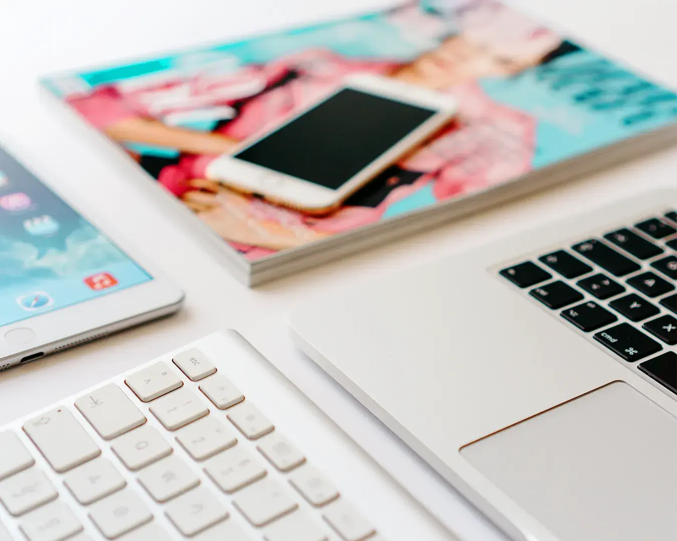 Minimalist workspace with smartphone, tablet and laptop representing native mobile apps versus mobile web applications for F&B businesses