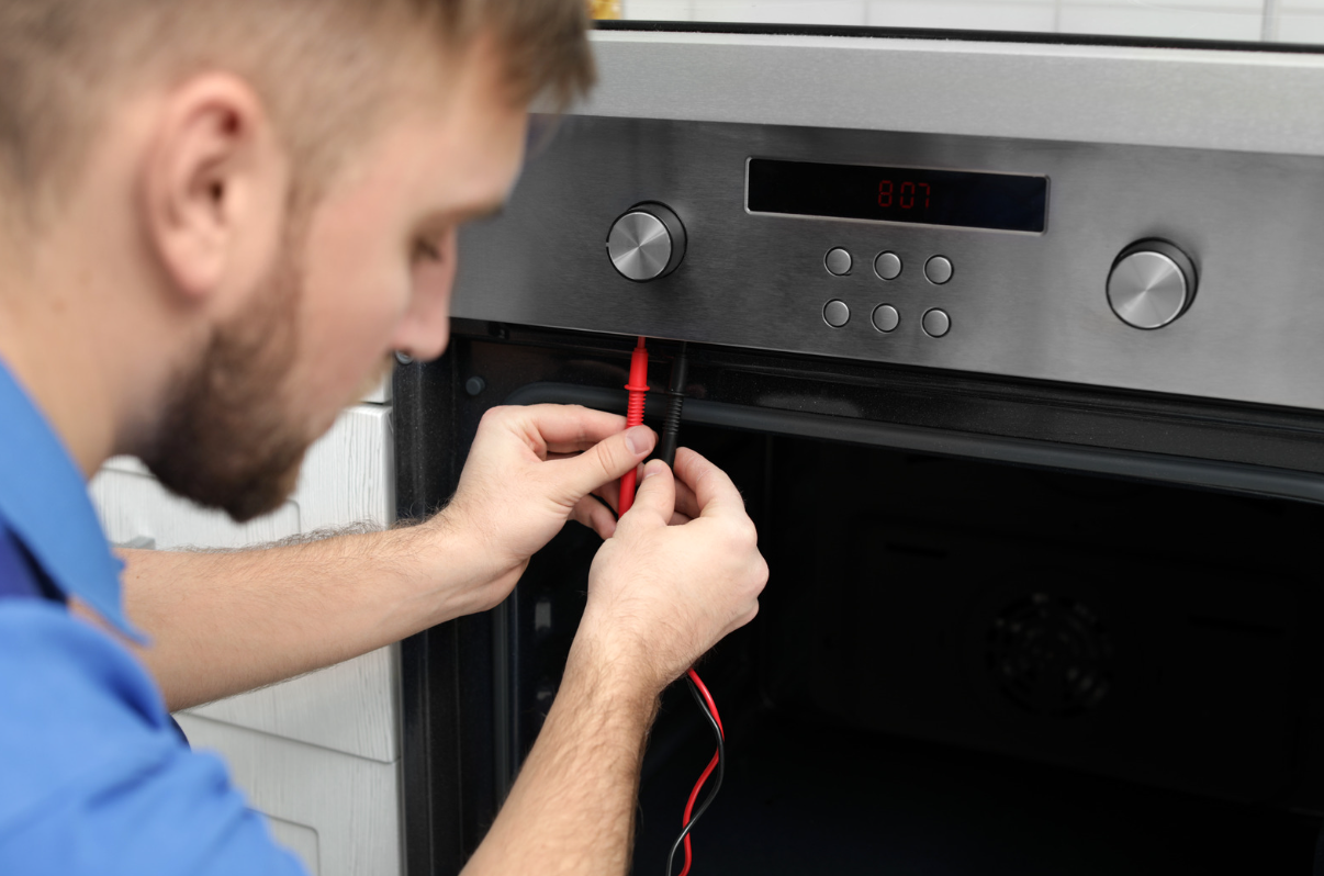 Young engineer wiring an oven