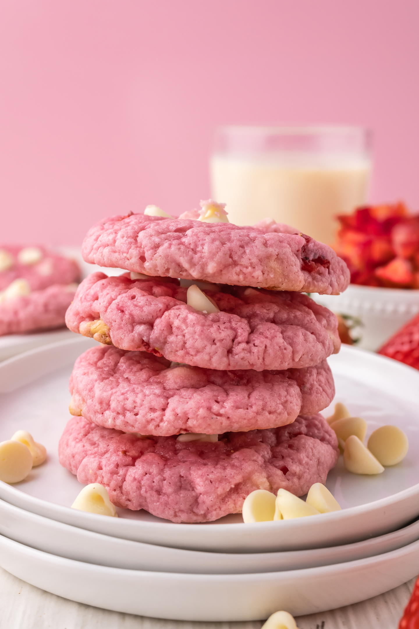 four strawberry white chocolate chip cookies stacked on a plate
