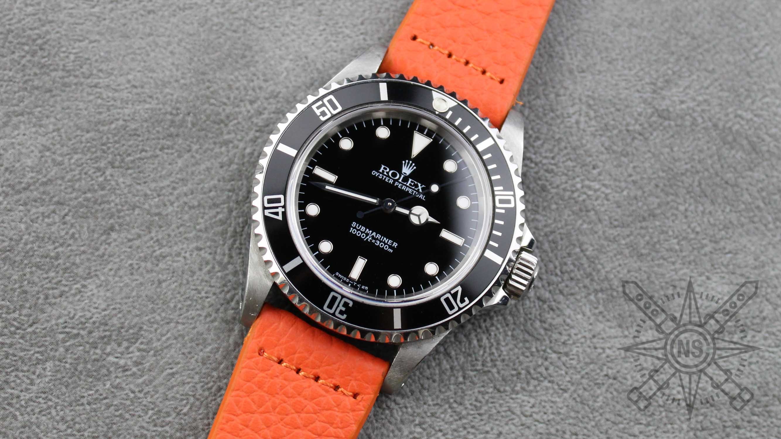 A stylish orange leather watch band displayed elegantly.