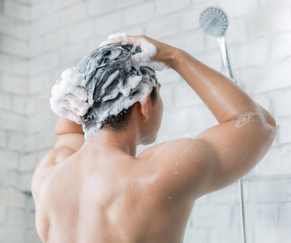 Man using hair growth shampoo in the shower