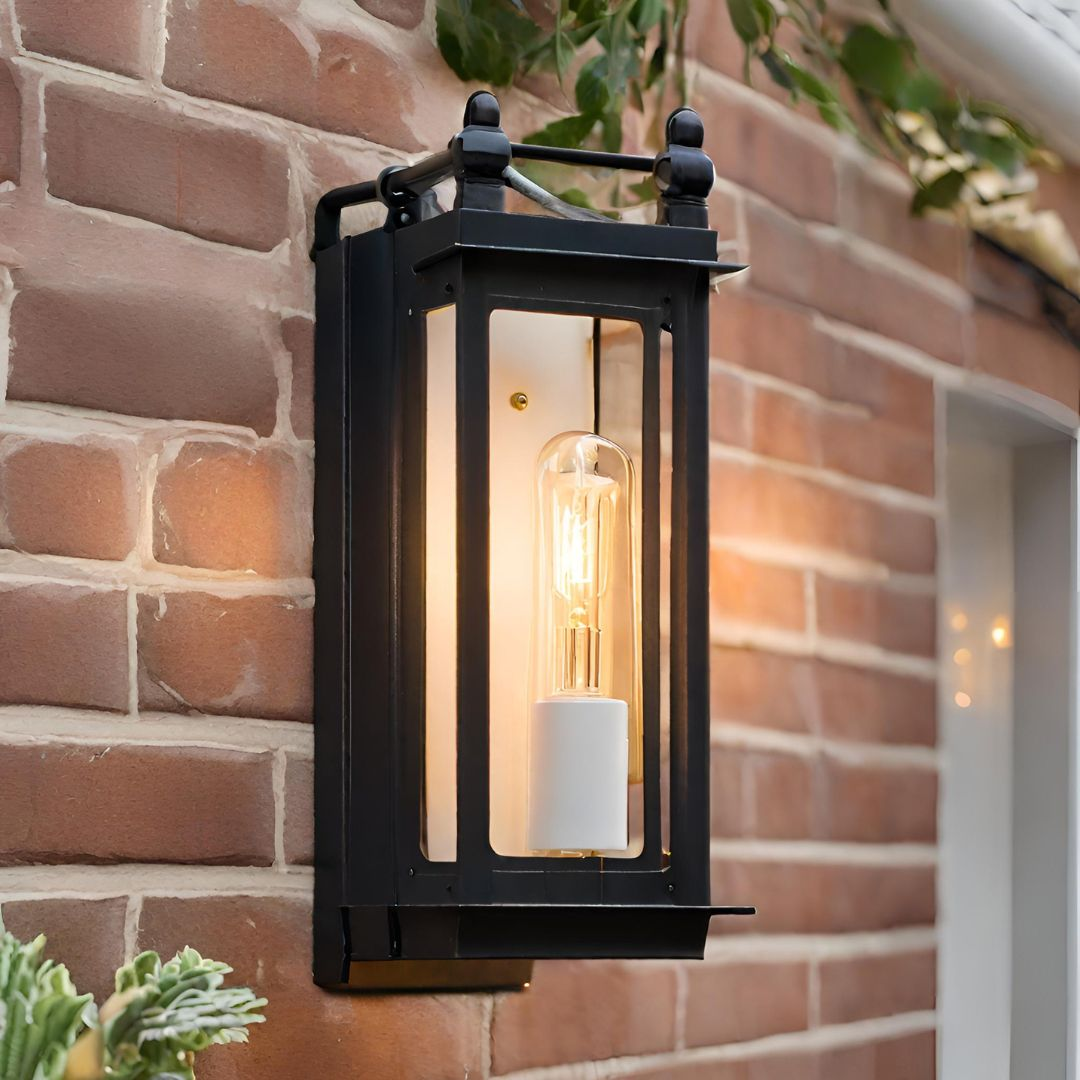 An exterior wall sconce with a incandescent bulb installed on a outdoor brick wall.