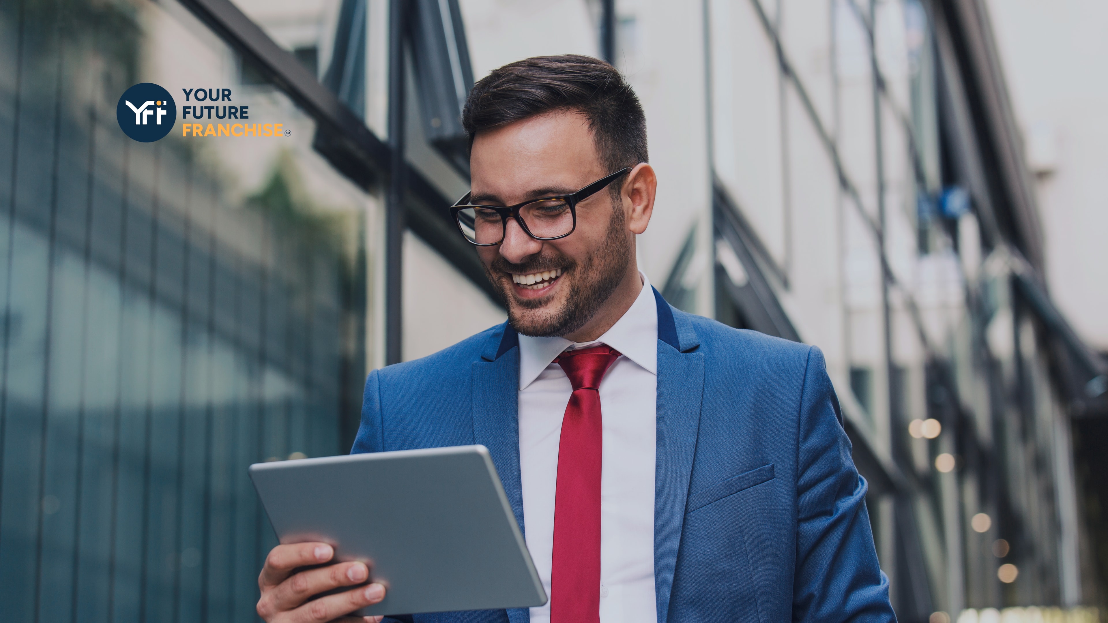 Businessman walking with an iPad smiling 