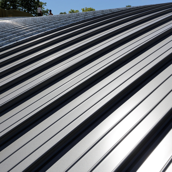 Image showing a homeowner admiring their new standing seam steel roof in San Antonio.