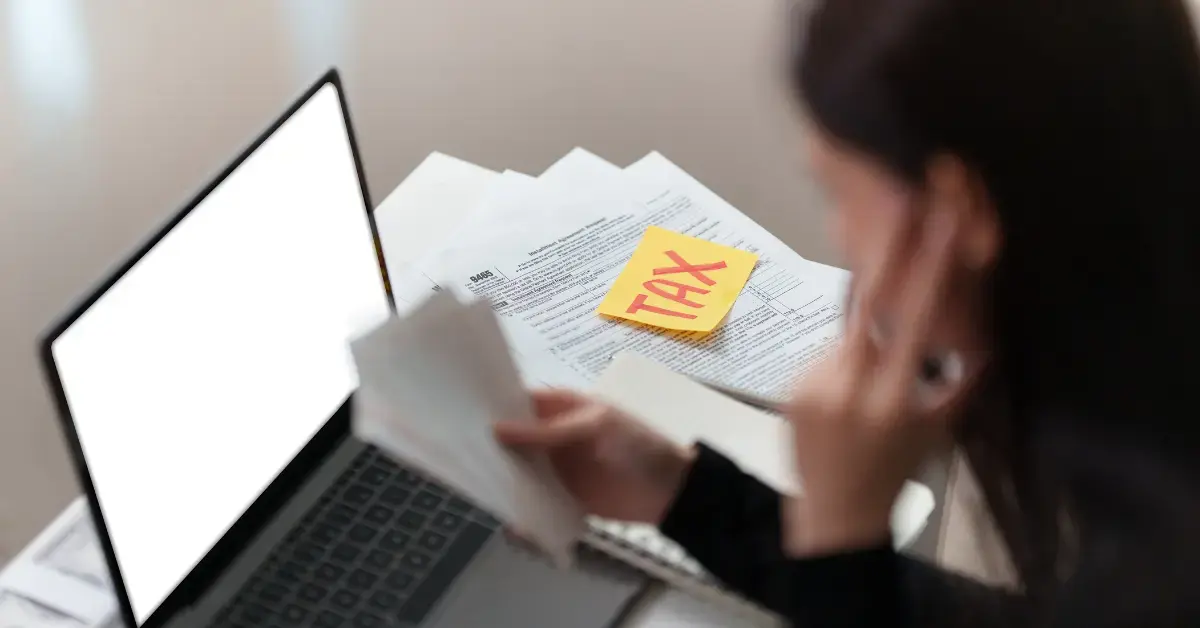 Woman reviewing IRS tax debt relief options with tax documents and income records.