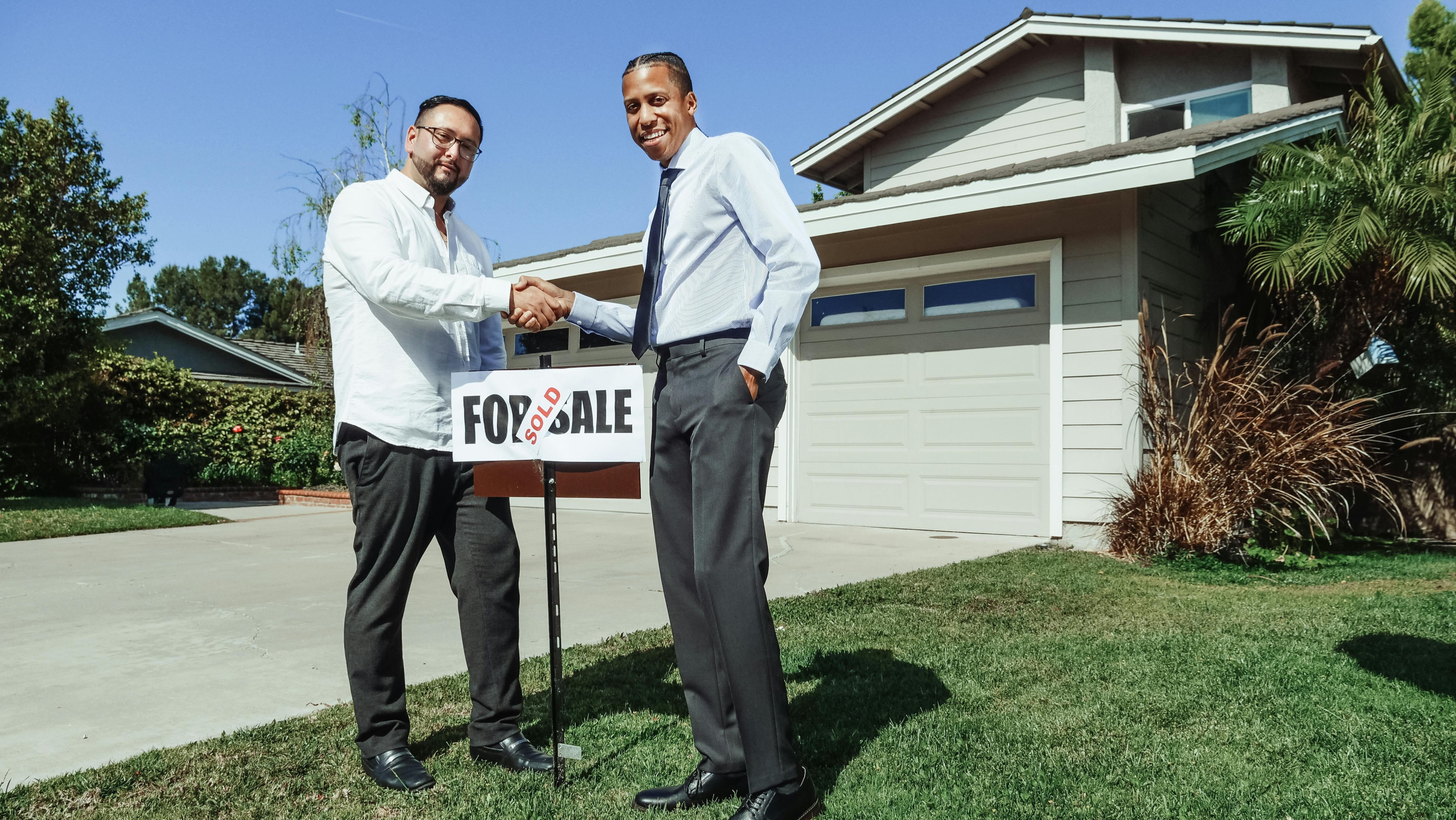 Real estate investor shakes hand of seller after successful property purchase.