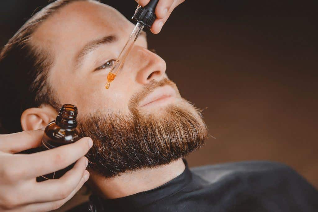 A person using a DIY beard oils to avoid beard dandruff with diet rich food to avoid hair damage and stay healthy