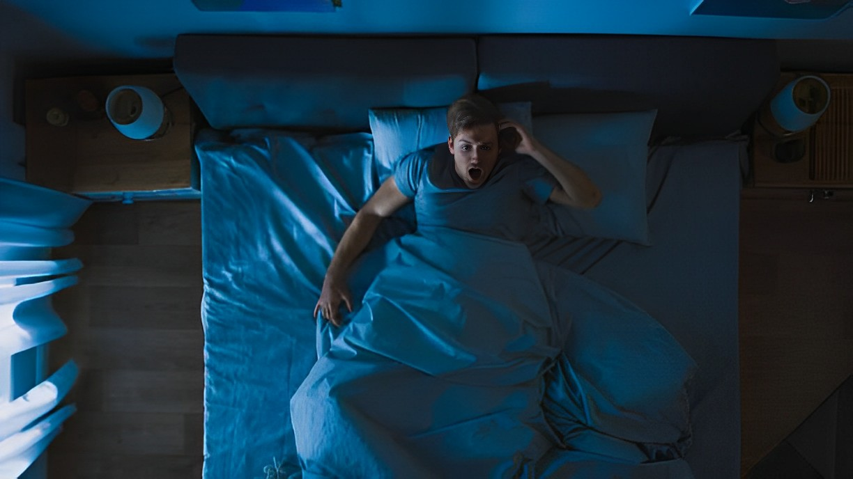 A photo of a man in shock in his bed