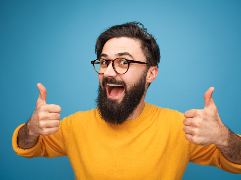 Homem feliz fazendo sinal positivo com os polegares. Foto: max-kegfire de Getty Images - Canva.