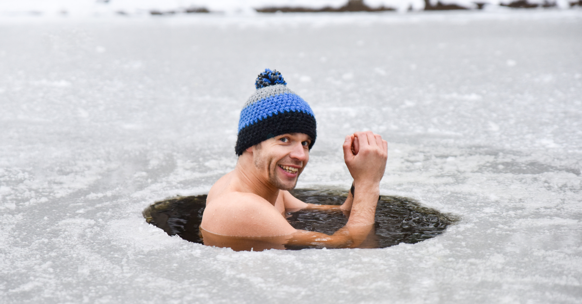 An image of a man experiencing cold stress in an ice bath cheering and feeling successful.