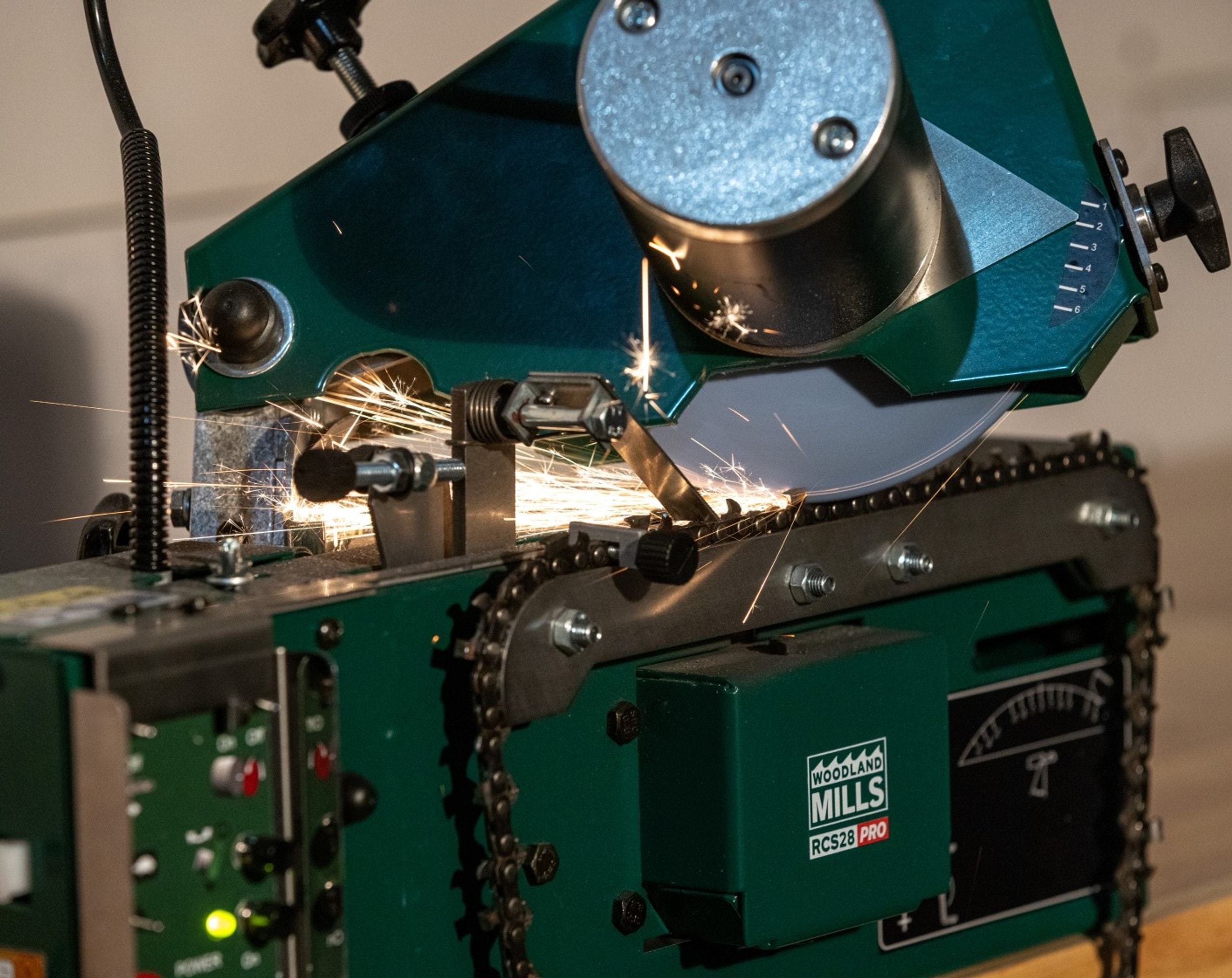 The grinding wheel of an RCS28 PRO Chainsaw Chain sharpener sharpening a chain at the correct angle.