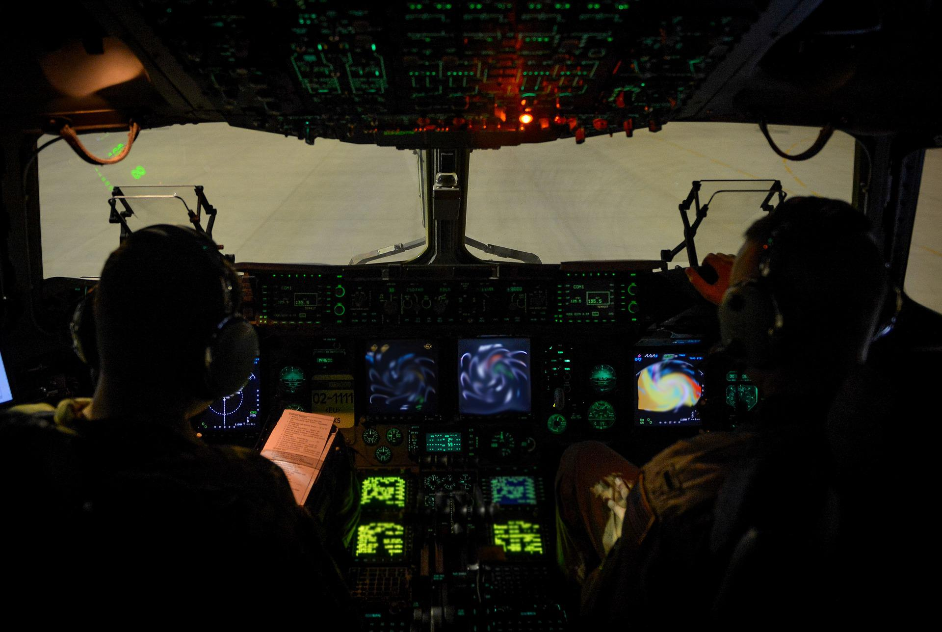 Two pilots preparing for a flight at night.