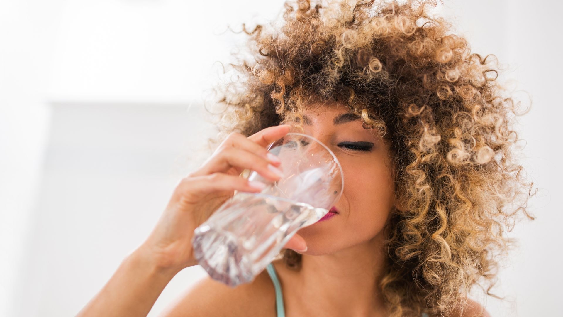 Kobieta pijąca czystą wodę w celach zdrowotnych