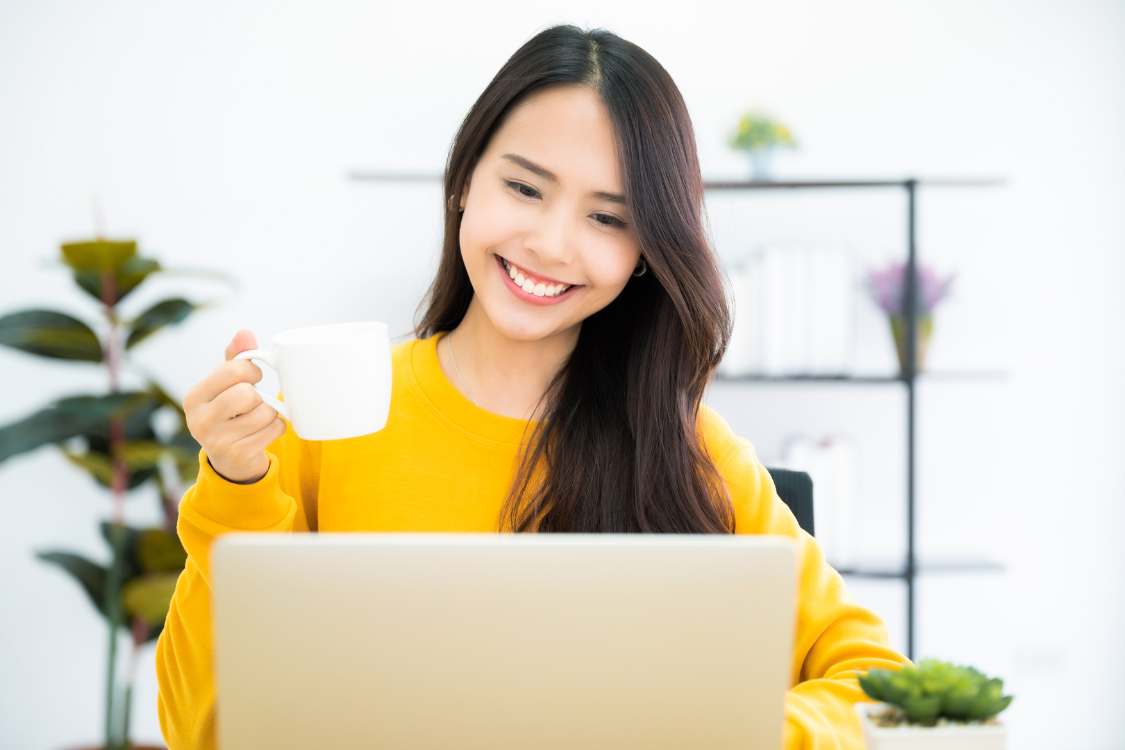 Smiling Filipino virtual assistant enjoying remote work with laptop