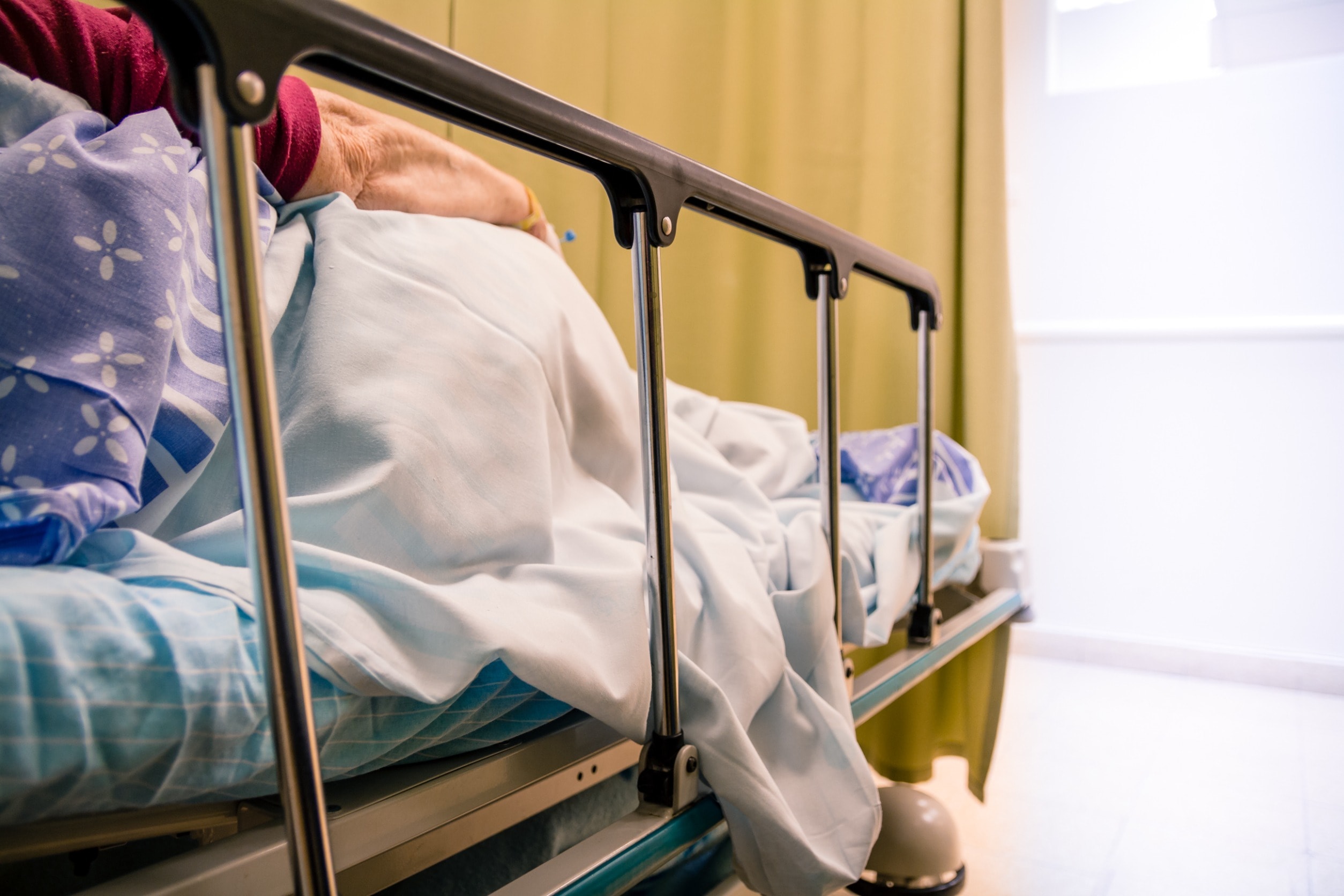 A woman lays in a hospital bed with pressure sores