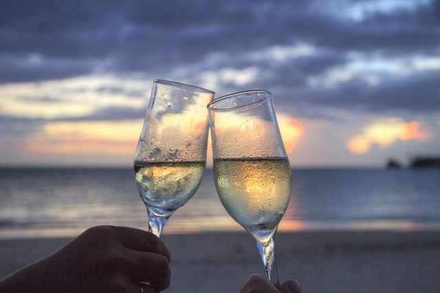 Two glasses clinking on beach sunset