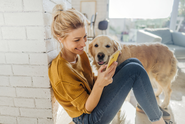 Happy blonde woman with a Golden retriever. 
