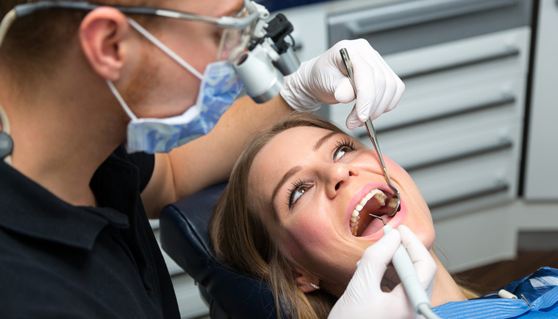 Tannlege undersøker tenner med speil og sonde.