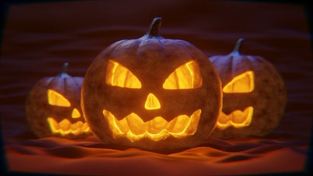A group of pumpkins with carved faces representing Halloween, an atumn festivity.